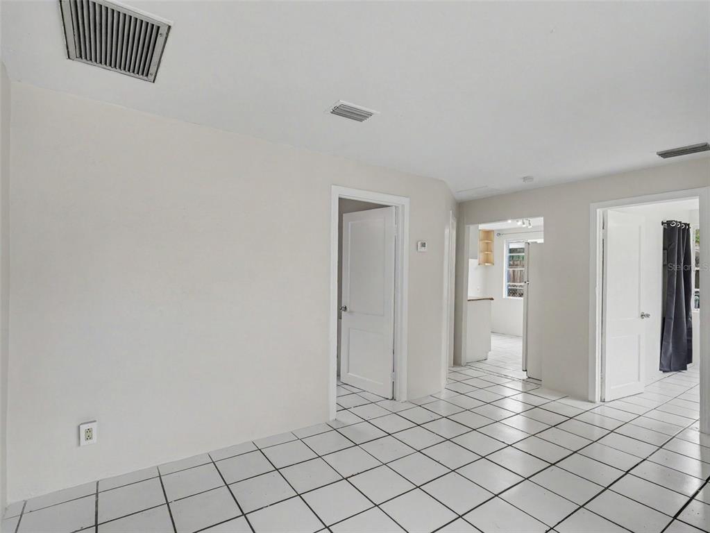 A room with white tiled floors, two doorways, and white walls with ceiling vents — 124 26TH AVENUE E UNIT A, BRADENTON, FL