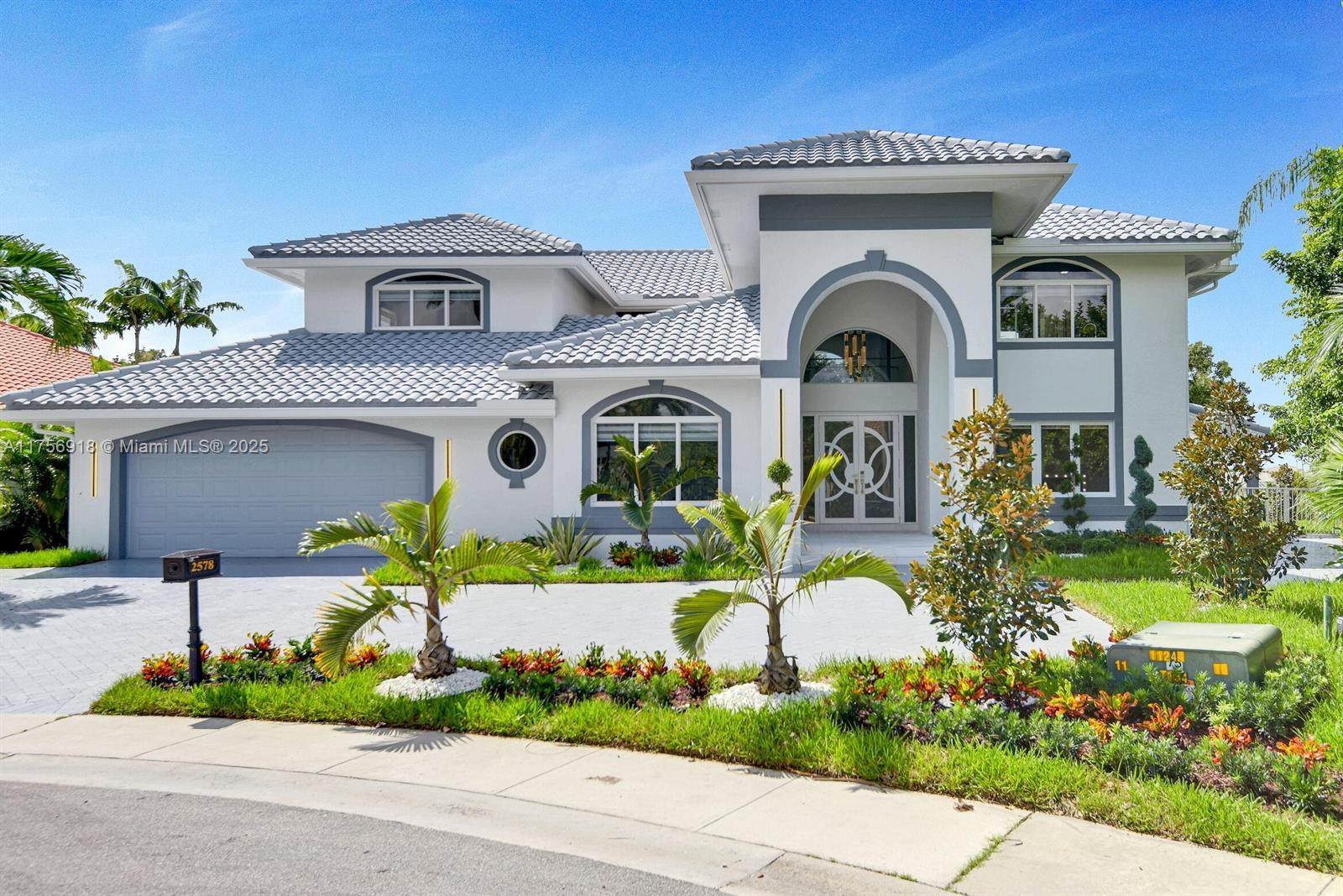 A two-story house with a gray tile roof, white stucco walls, and a paved driveway — 2578 NW 63rd Ln, Boca Raton FL 33496, BOCA RATON, FL