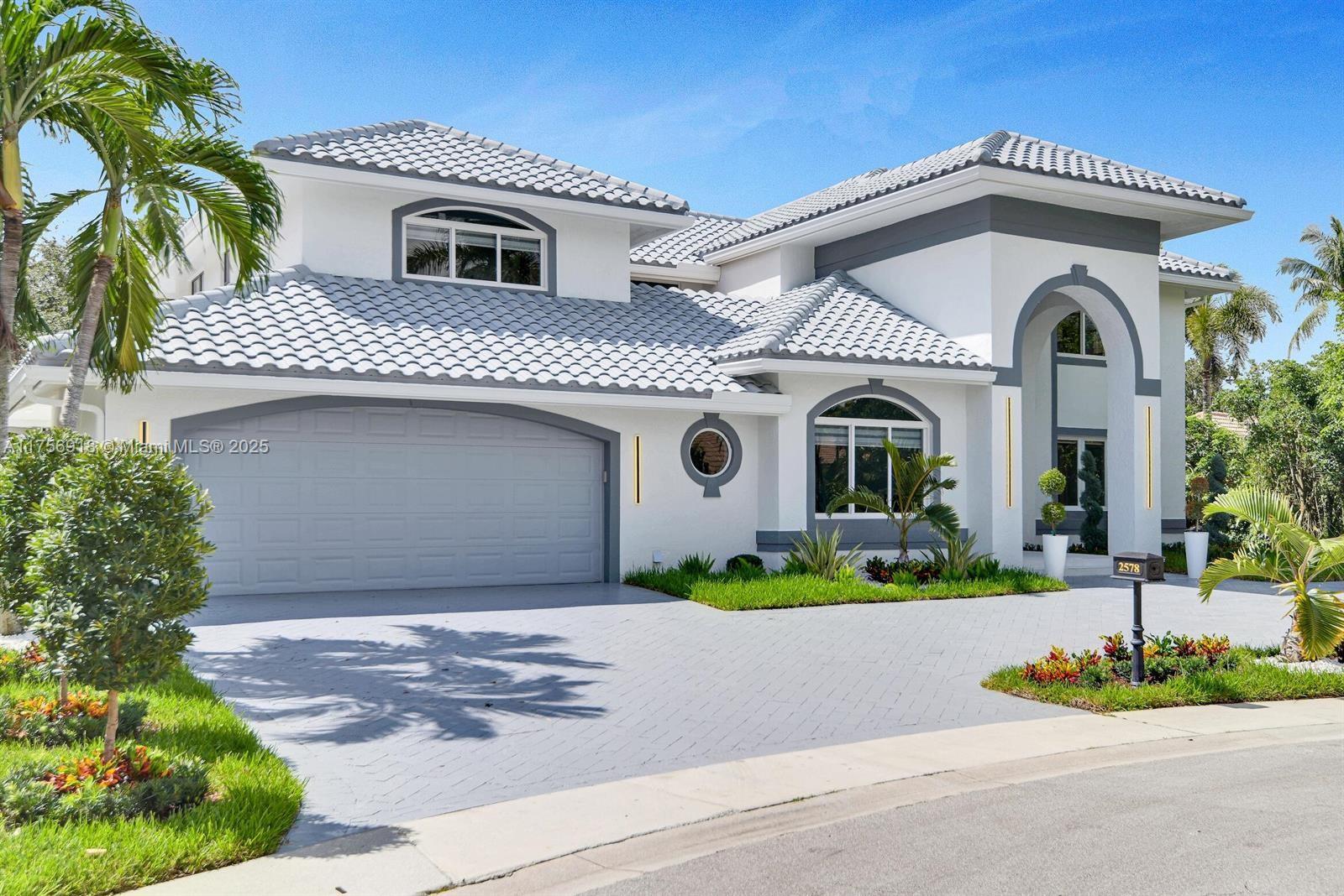 A two-story house with a gray tiled roof, white stucco walls, and a paved driveway — 2578 NW 63rd Ln, Boca Raton FL 33496, BOCA RATON, FL