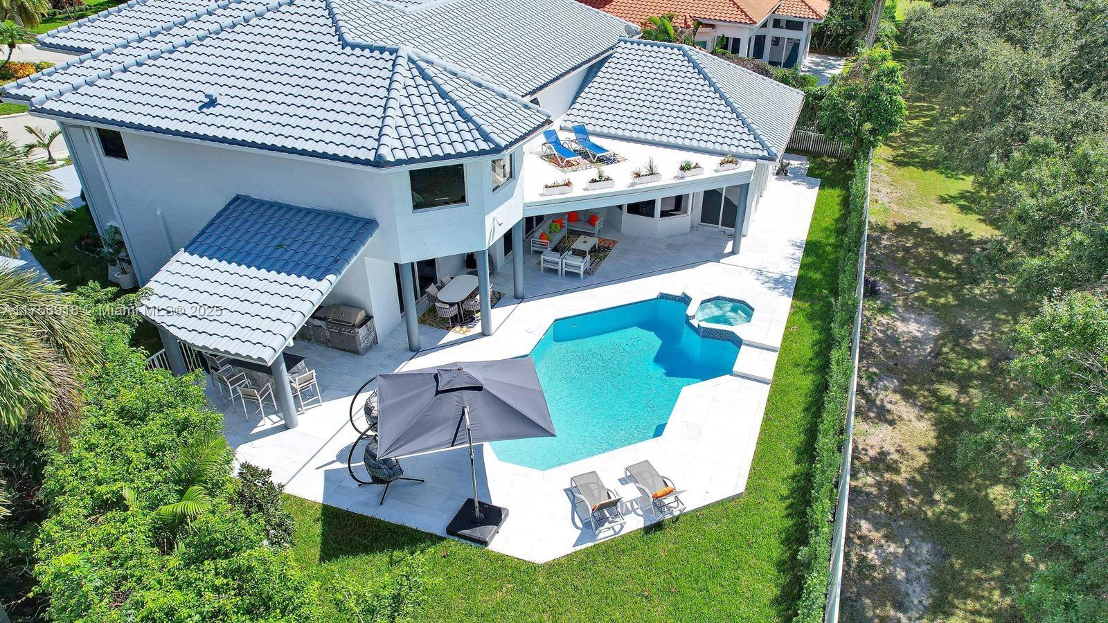 An aerial view of a two-story house with a swimming pool, patio, and backyard — 2578 NW 63rd Ln, Boca Raton FL 33496, BOCA RATON, FL