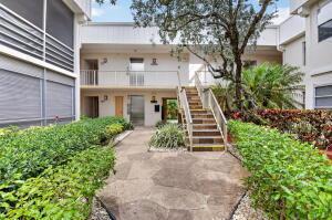 A stone walkway leads to a wooden staircase between two levels of a residential building — 133 Capri # C, Delray Beach FL 33484, DELRAY BEACH, FL
