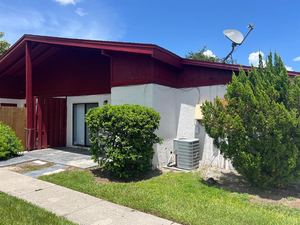 A single-story building with white stucco walls, red shutters, and a stone-accented corner — 4123 SPITFIRE, KISSIMMEE, FL