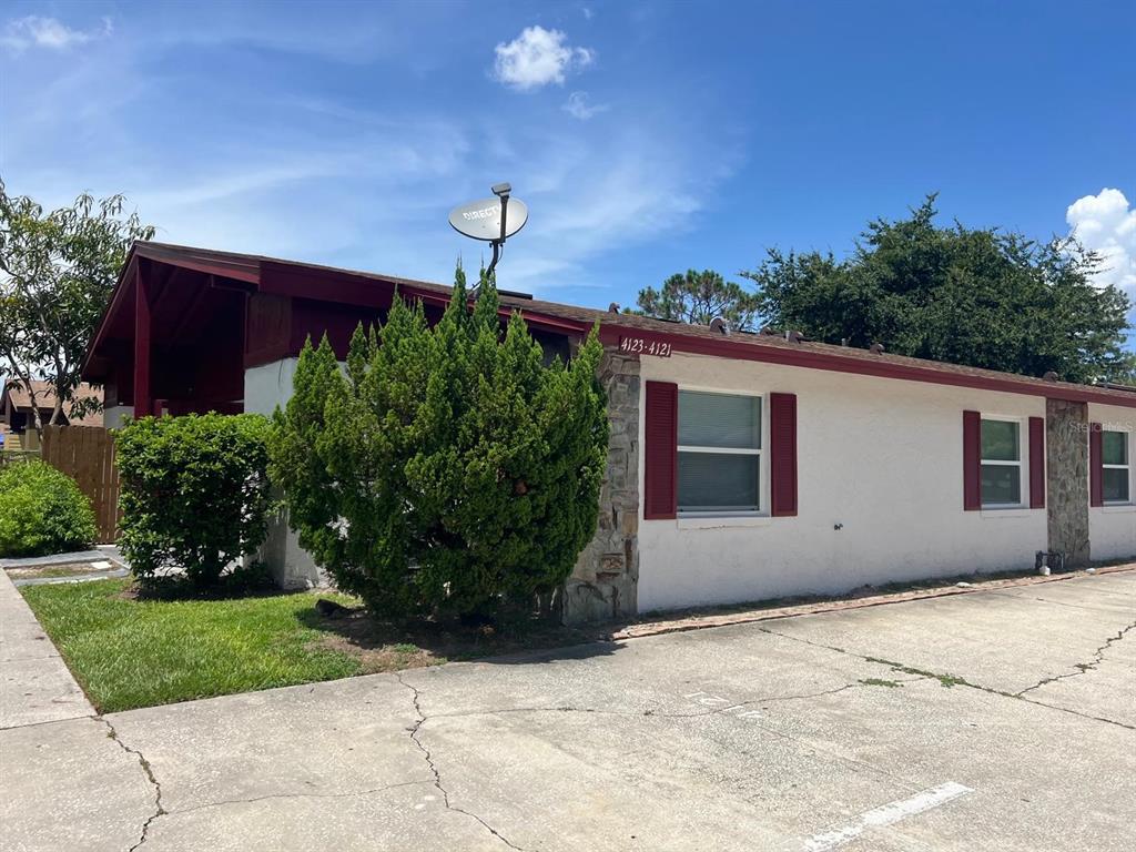 An empty room features gray walls, light wood-look flooring, a ceiling fan, and vertical blinds — 4123 SPITFIRE, KISSIMMEE, FL
