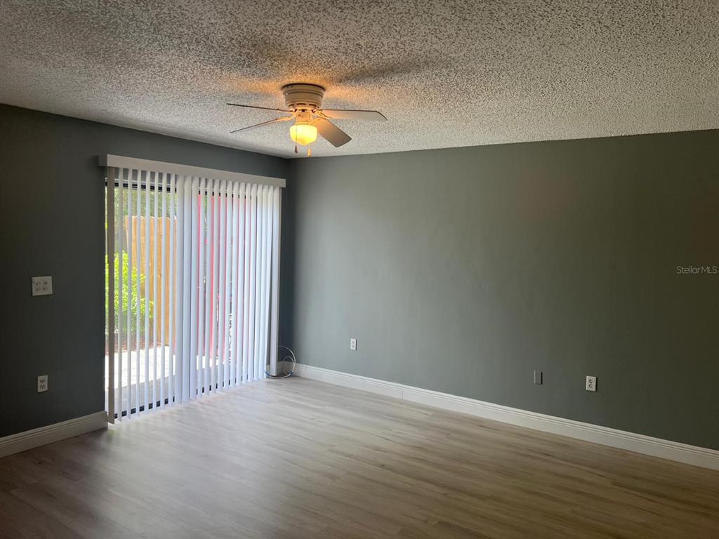 An empty room features gray walls, a ceiling fan, and light-colored wood-look flooring — 4123 SPITFIRE, KISSIMMEE, FL