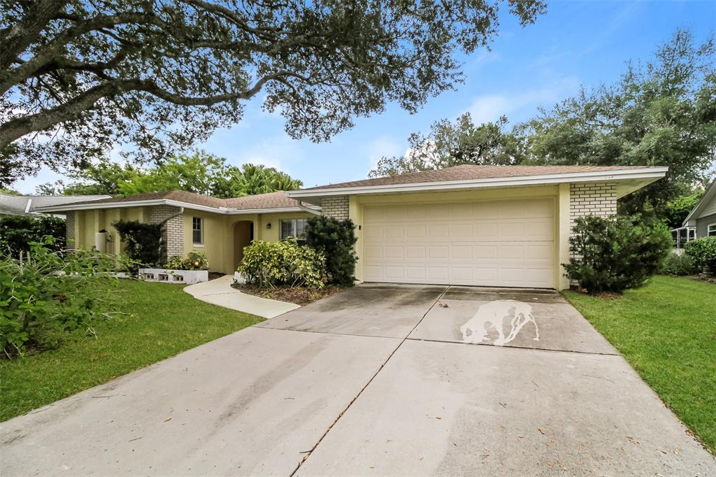 A single-story house with a yellow exterior, a two-car garage, and a concrete driveway — 745 LITTLE WEKIVA CIRCLE, ALTAMONTE SPRINGS, FL