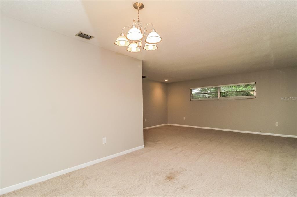 An empty room with beige carpet, light walls, and a multi-light chandelier — 745 LITTLE WEKIVA CIRCLE, ALTAMONTE SPRINGS, FL