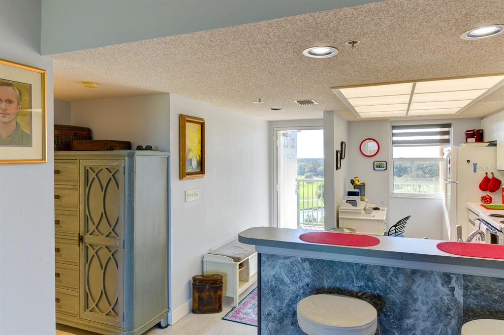 A kitchen with a breakfast bar, gray cabinetry, and a doorway leading to a balcony — 2320 TERRA CEIA BAY BOULEVARD UNIT 811, PALMETTO, FL