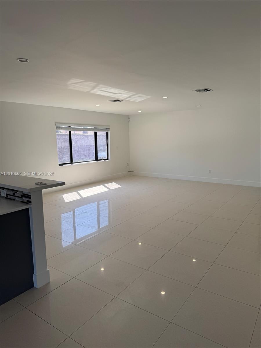 An empty room with white walls, large light-colored floor tiles, and a single window — 3155 SW 132nd Ave, Miami FL 33175, MIAMI, FL