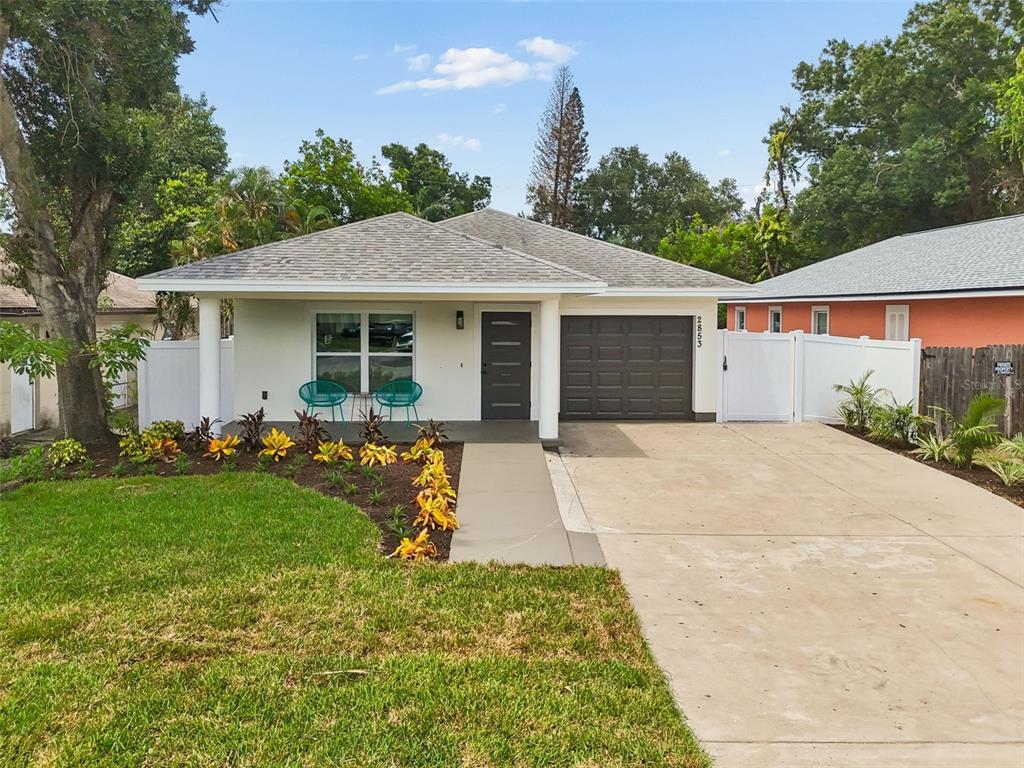 A single-story house with a white exterior, a covered porch, and a landscaped front yard — 2853 35TH AVENUE N, ST PETERSBURG, FL