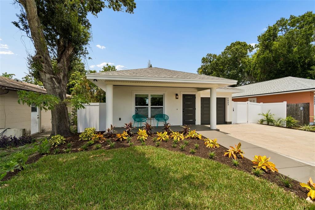 A single-story house with a white exterior, a front porch, and a concrete driveway — 2853 35TH AVENUE N, ST PETERSBURG, FL