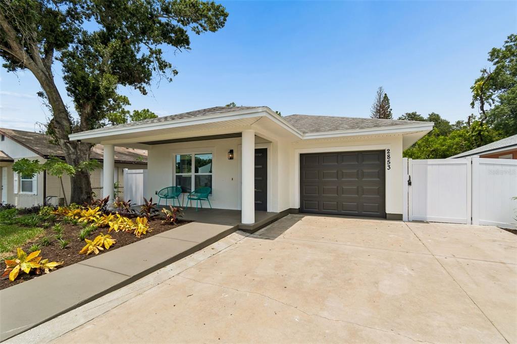 A single-story house with a white exterior, dark front door, and a small front lawn — 2853 35TH AVENUE N, ST PETERSBURG, FL