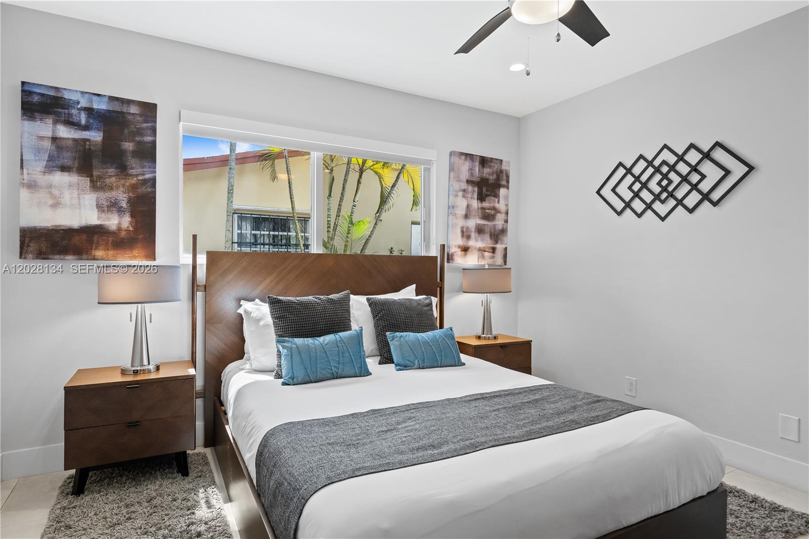 A bedroom features a wooden bed frame, two nightstands with lamps, and wall art — 1329 Funston, Hollywood FL 33019, HOLLYWOOD, FL
