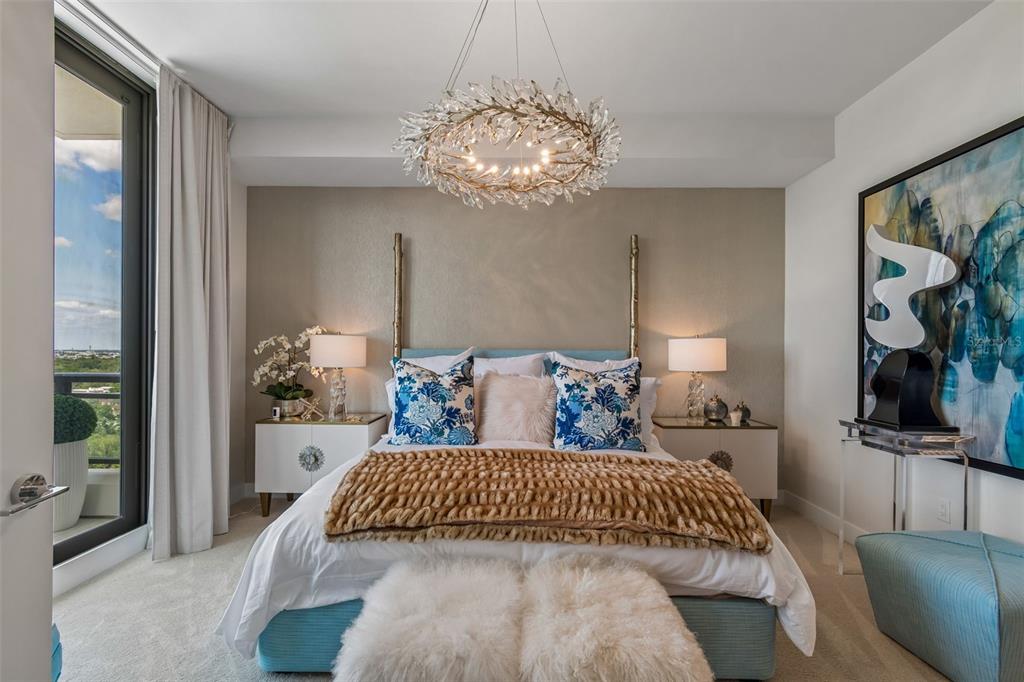 A bedroom features a blue upholstered bed, a crystal chandelier, and a balcony with views — 2103 BAYSHORE BOULEVARD UNIT 1203, TAMPA, FL