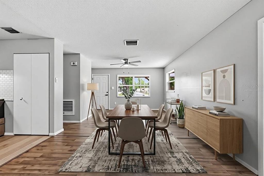 A dining room features a wooden table, six chairs, a sideboard, and wood-look flooring — 2151 S IVEY LANE, ORLANDO, FL