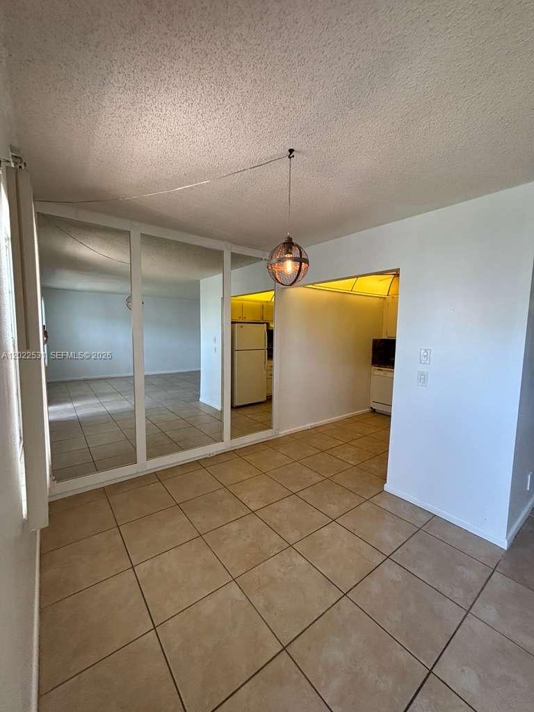 A dining area features tiled floors, a hanging pendant light, and mirrored closet doors — 531 Fanshaw M # 531, Boca Raton FL 33434, BOCA RATON, FL