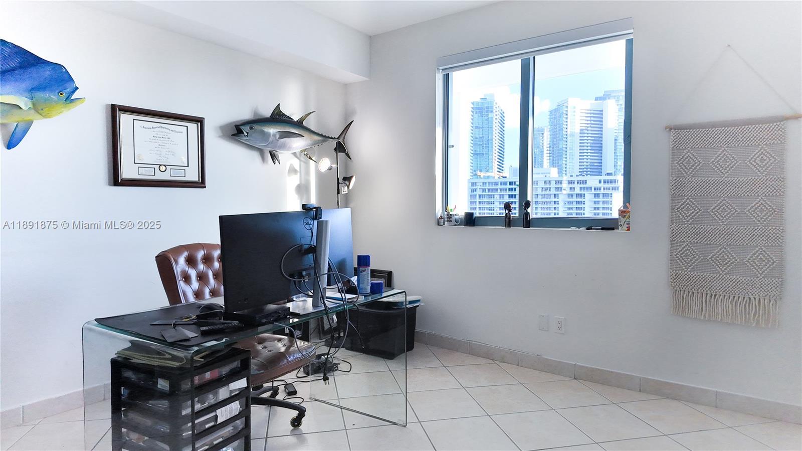 A home office features a glass desk, leather chair, fish wall decor, and city views — 601 NE 36th St # 2206, Miami FL 33137, MIAMI, FL