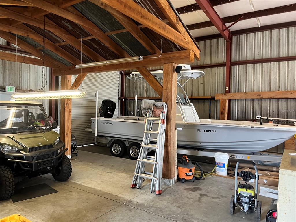 A large, open-walled storage building houses a boat on a trailer and an all-terrain vehicle — 177 US HIGHWAY 27 S, SEBRING, FL