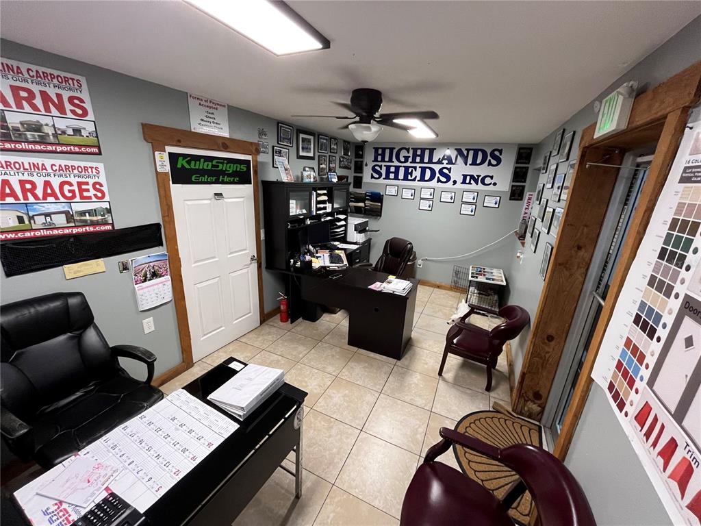 An office space features two desks, chairs, tiled flooring, and wall-mounted signage for various businesses — 177 US HIGHWAY 27 S, SEBRING, FL