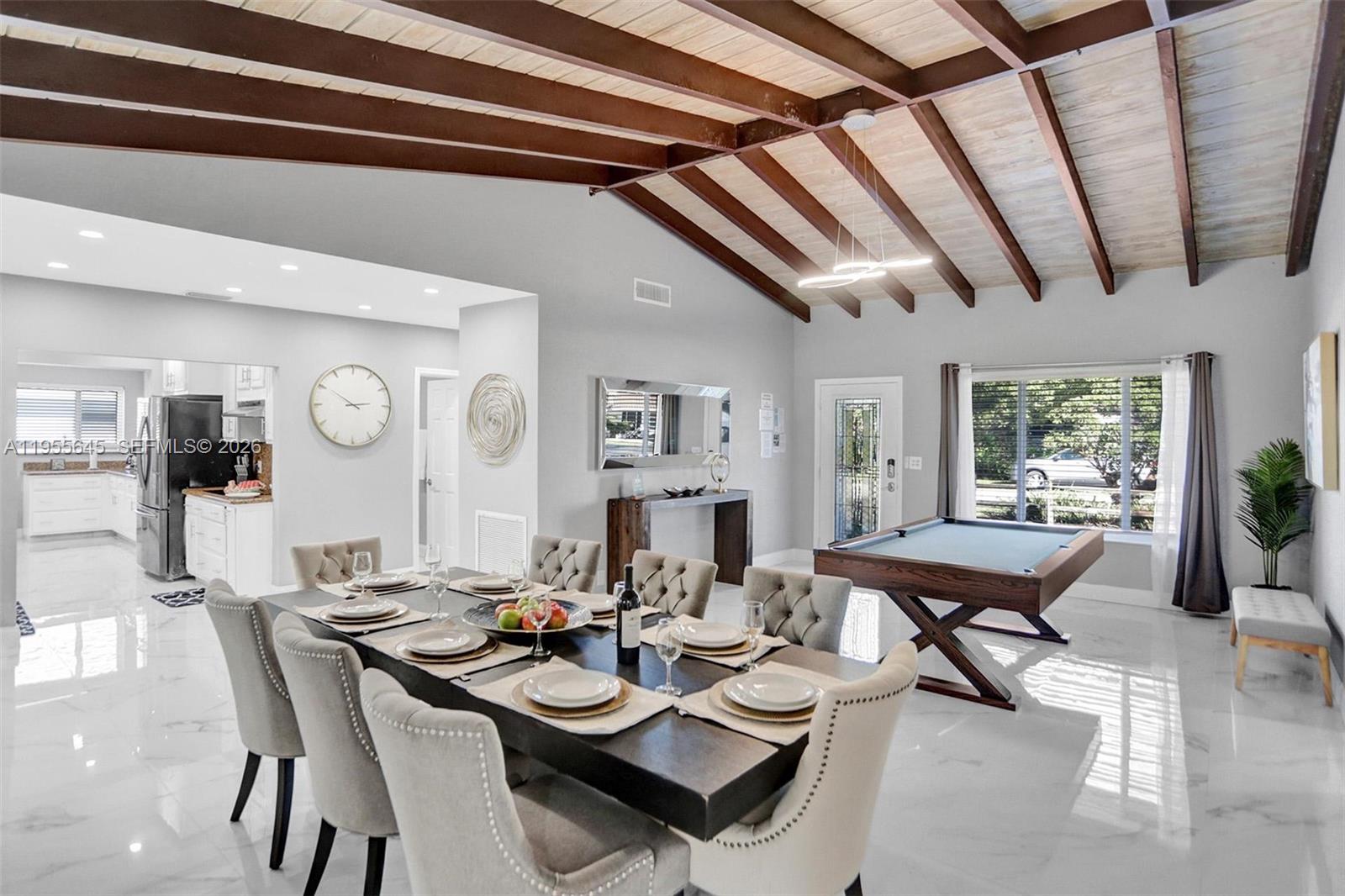 A dining room with a pool table features vaulted wood-beam ceilings and white marble floors — 2797 NE 21st Ter, Lighthouse Point FL 33064, LIGHTHOUSE POINT, FL