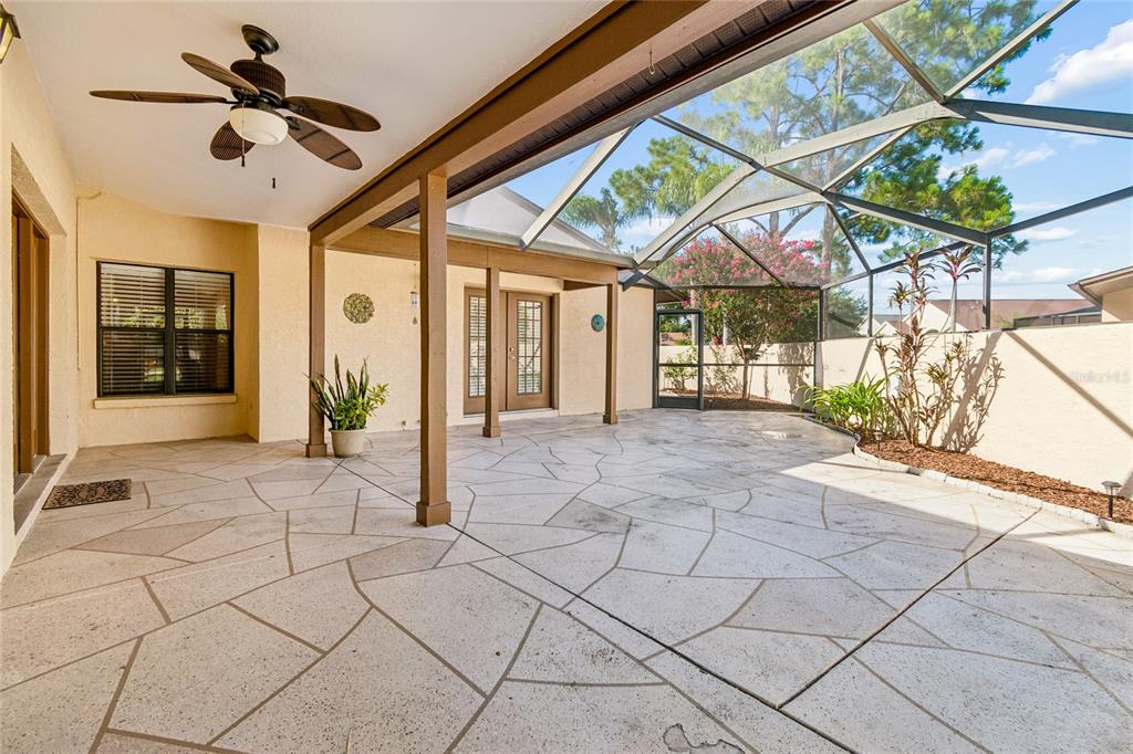 A covered patio with a screened enclosure, concrete flooring, and a ceiling fan — 5030 UMBER WAY N, TAMPA, FL