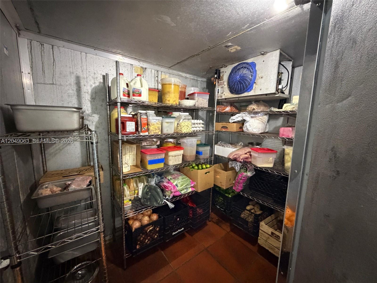 A walk-in refrigerator features metal shelving units stocked with various food containers and produce crates — Restaurant space NW For Lease, Miami FL 33122, MIAMI, FL