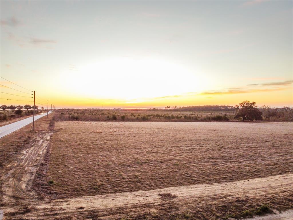 An aerial view of a large, flat, grassy vacant lot next to a paved road — 4366 ROYAL SKY (LOT 2) COURT, BROOKSVILLE, FL