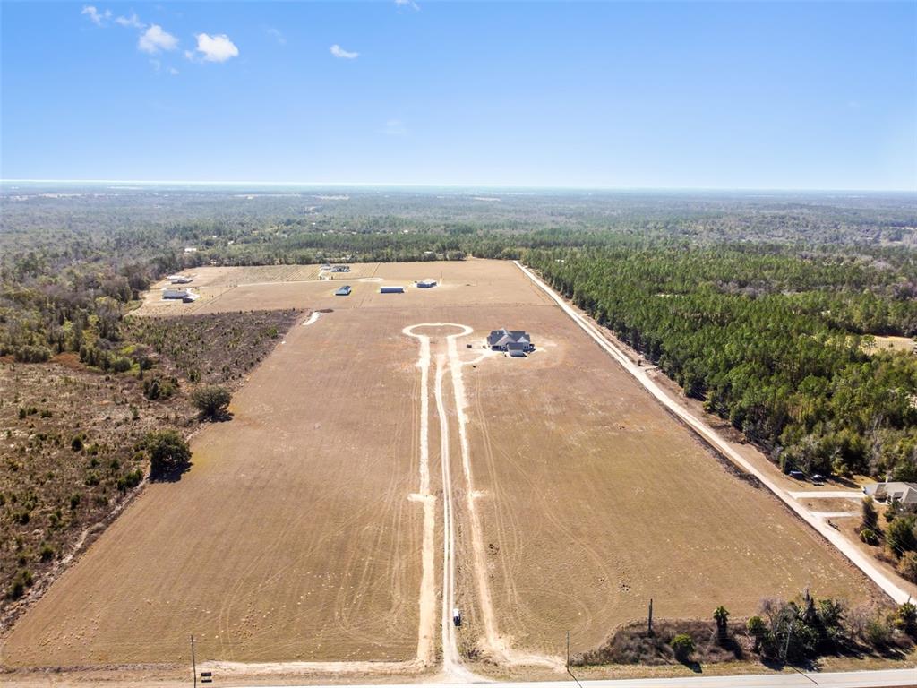 An aerial view shows a large, cleared lot with a single house and driveway — 4366 ROYAL SKY (LOT 2) COURT, BROOKSVILLE, FL