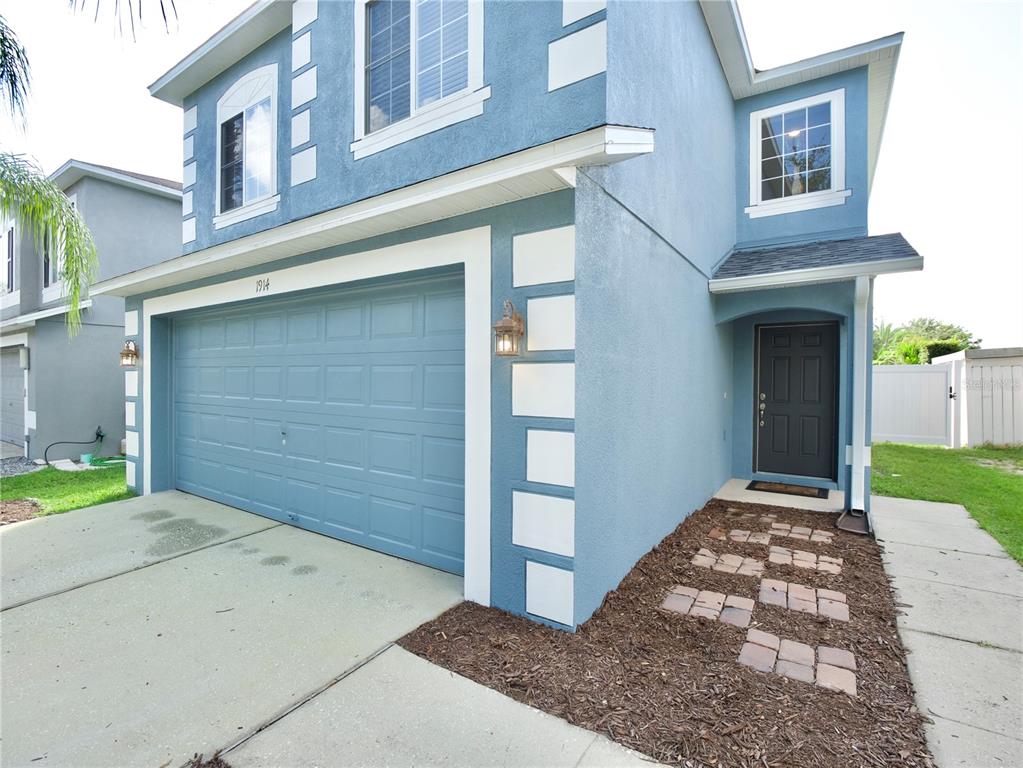 A two-story blue house features a two-car garage, white corner accents, and a front entrance — 1914 SHERBOURNE STREET, WINTER GARDEN, FL