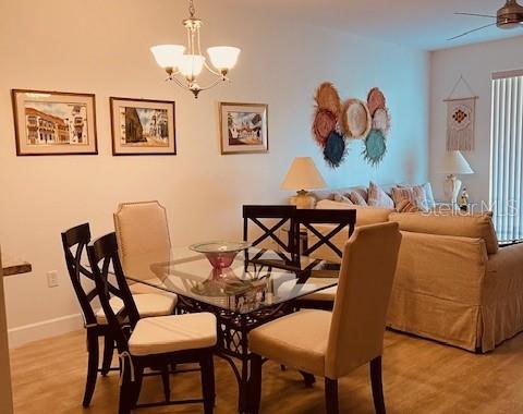A dining area with a glass table and chairs sits adjacent to a living room sofa — 8735 OLDE HICKORY AVENUE UNIT 8104, SARASOTA, FL