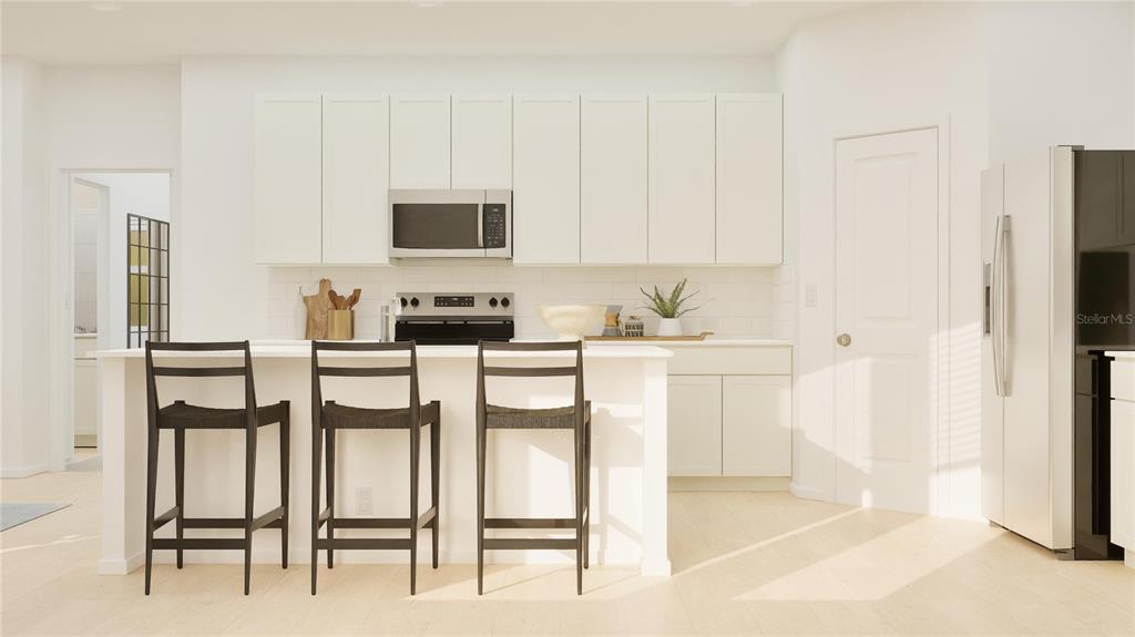 This kitchen features white cabinets, a central island with three stools, and stainless steel appliances — 6048 BALANCE WAY, CLERMONT, FL