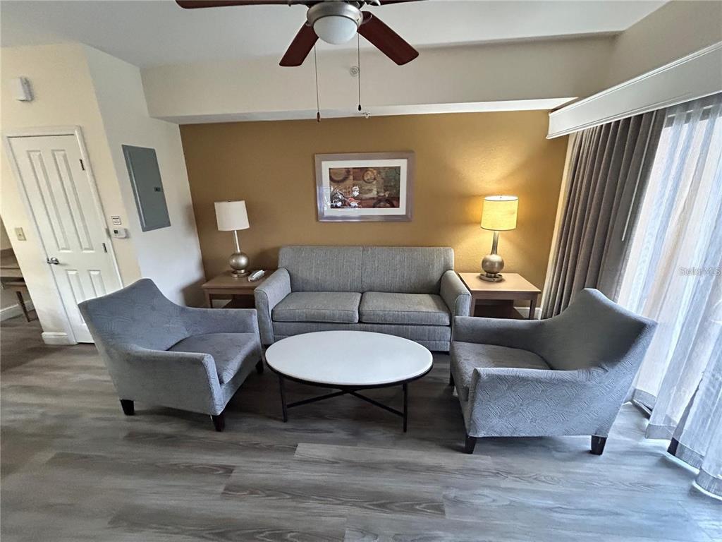 A living room features a gray sofa, two armchairs, a round coffee table, and lamps — 12544 FLORIDAYS RESORT DRIVE UNIT 402B, ORLANDO, FL