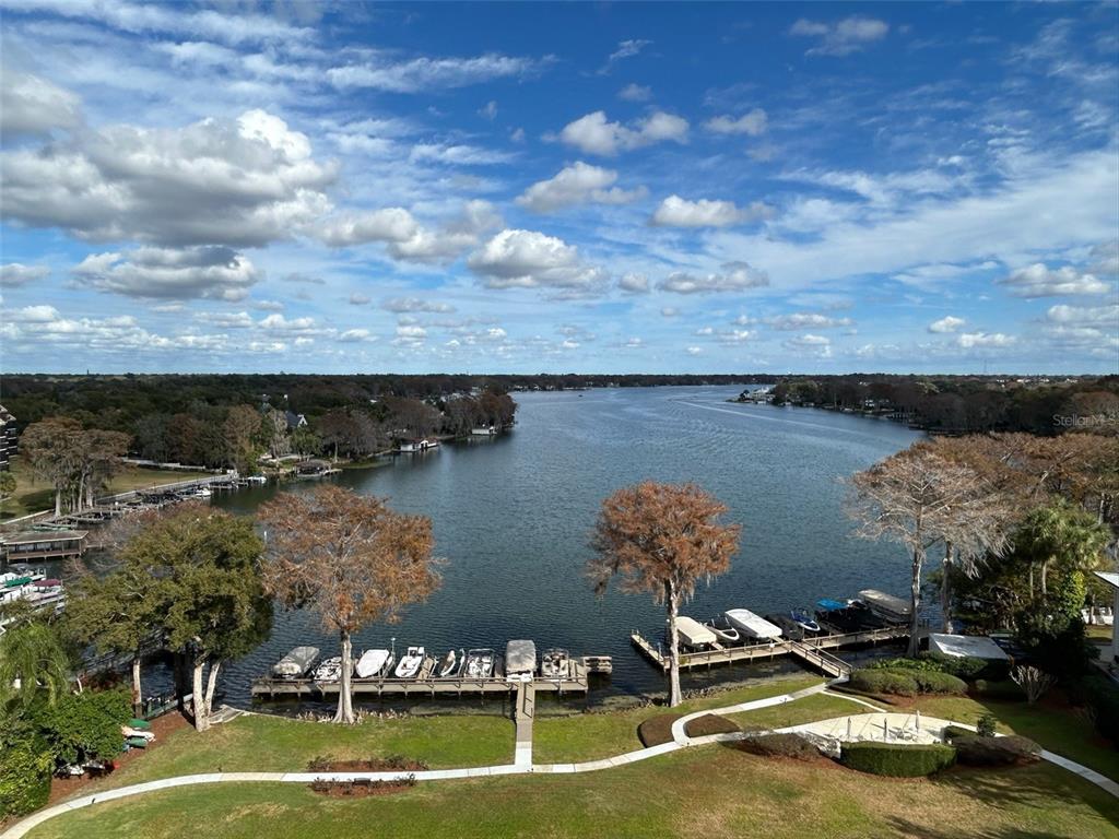 An elevated view of a lake with boat docks and surrounding trees under a cloudy sky — 1100 S ORLANDO AVENUE UNIT 956, MAITLAND, FL