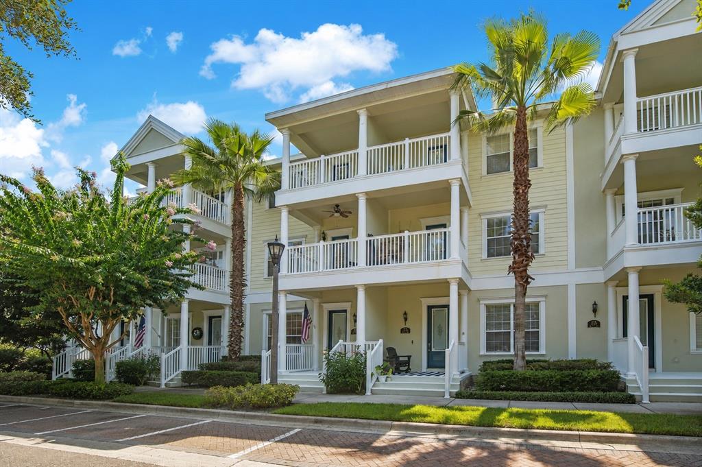 A three-story apartment building with white balconies, palm trees, and a brick parking area — 227 MCLEODS WAY, WINTER SPRINGS, FL