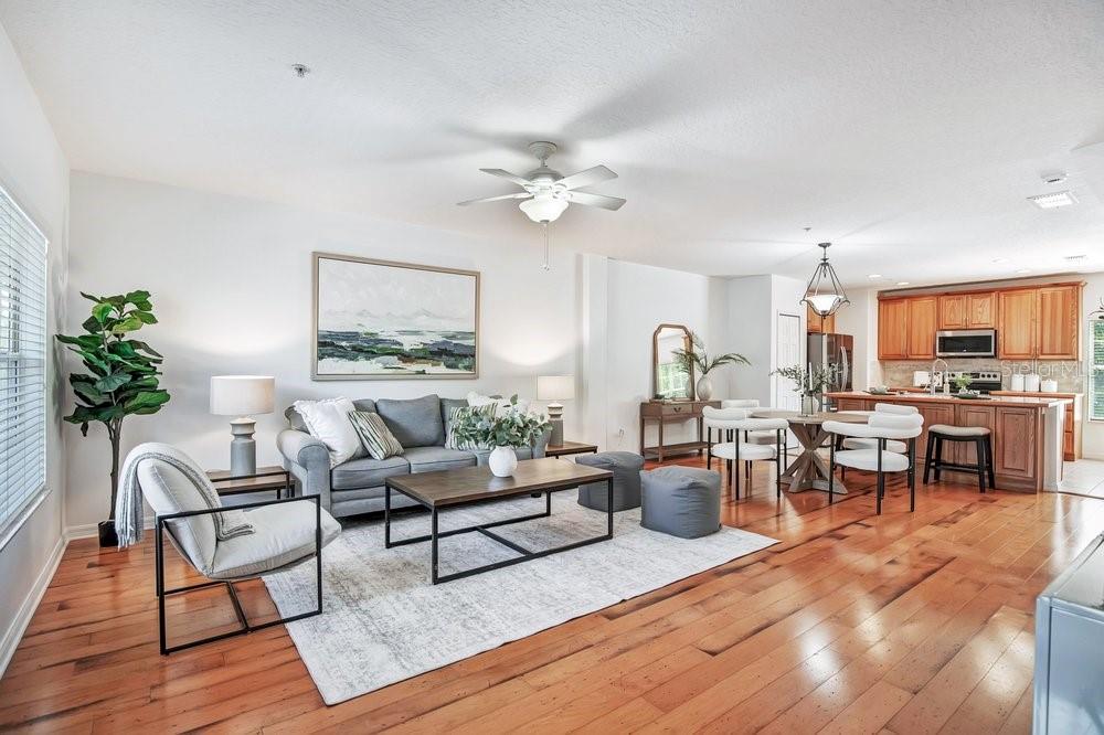 A living room with hardwood floors, a gray sofa, a coffee table, and a ceiling fan — 227 MCLEODS WAY, WINTER SPRINGS, FL