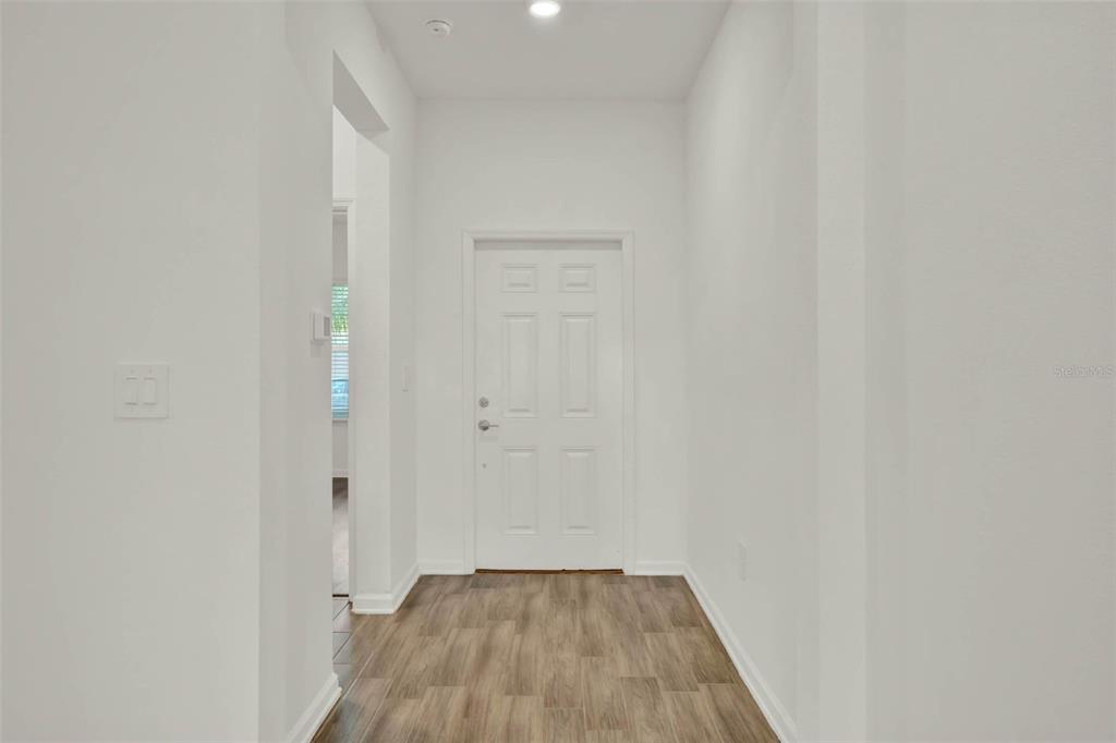 A bright entryway features white walls, a white front door, and wood-look flooring — 8114 SAYINGS DRIVE, WINTER GARDEN, FL