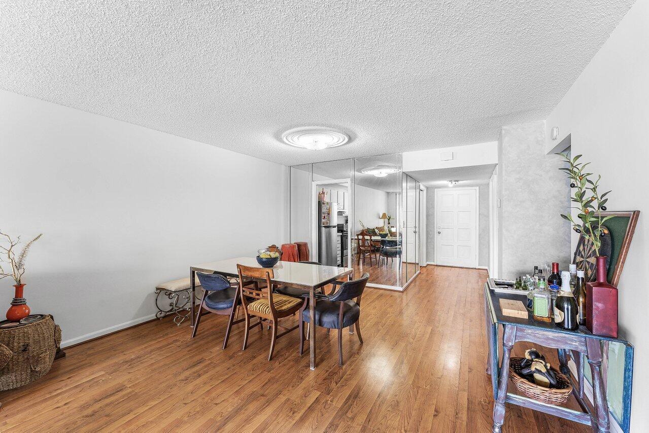 A dining room with hardwood floors, a glass-top table, and mirrored walls — 157 Atlantis Boulevard # 301, Atlantis FL 33462, ATLANTIS, FL