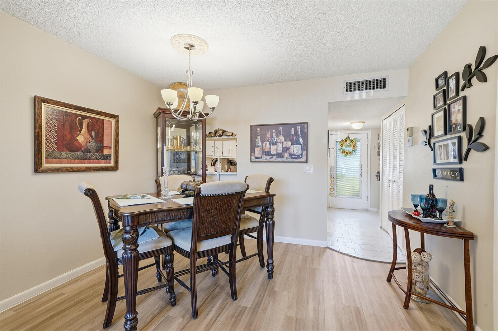 A dining room with a wooden table, chairs, a hutch, and a wall gallery display — 3130 Holiday Springs Boulevard # 103, Margate FL 33063, MARGATE, FL