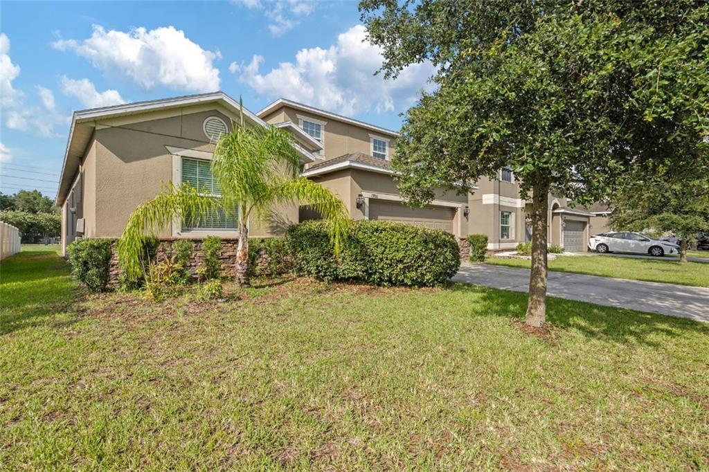 A two-story suburban house with a tan stucco exterior, a palm tree, and a driveway — 13801 NEWPORT SHORES DRIVE, HUDSON, FL