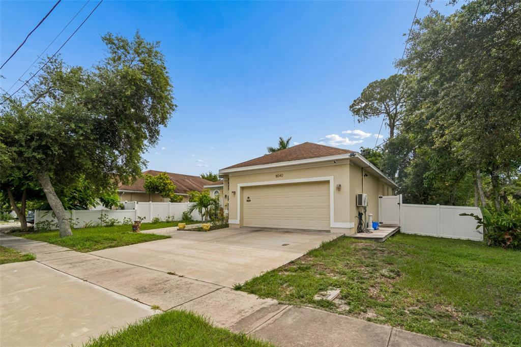 A beige detached garage with a concrete driveway sits on a grassy residential lot — 8040 57TH STREET N, PINELLAS PARK, FL