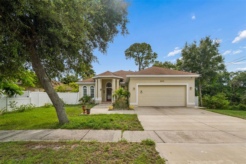 A single-story house with a beige exterior, a two-car garage, and a red front door — 8040 57TH STREET N, PINELLAS PARK, FL
