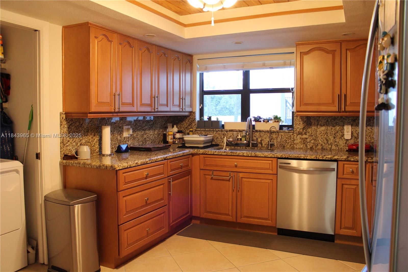A kitchen features wood cabinets, granite countertops, stainless steel appliances, and a window above the sink — 16051 Blatt Blvd # 106, Weston FL 33326, WESTON, FL