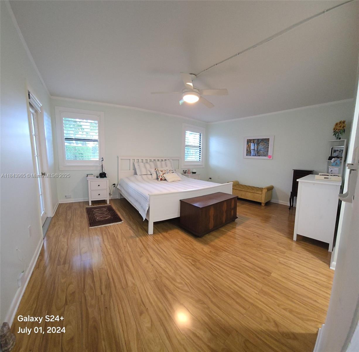 A bedroom with light-colored walls, wood flooring, a white bed frame, and a ceiling fan — 16051 Blatt Blvd # 106, Weston FL 33326, WESTON, FL