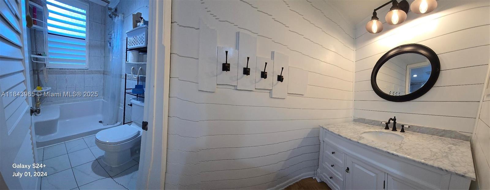 A bathroom features white shiplap walls, a marble-topped vanity, and a separate toilet and shower — 16051 Blatt Blvd # 106, Weston FL 33326, WESTON, FL