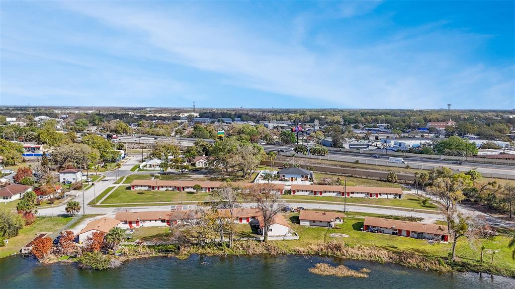 An aerial view shows a single-story apartment complex situated next to a lake and highway — 2222 W SOUTH STREET, ORLANDO, FL