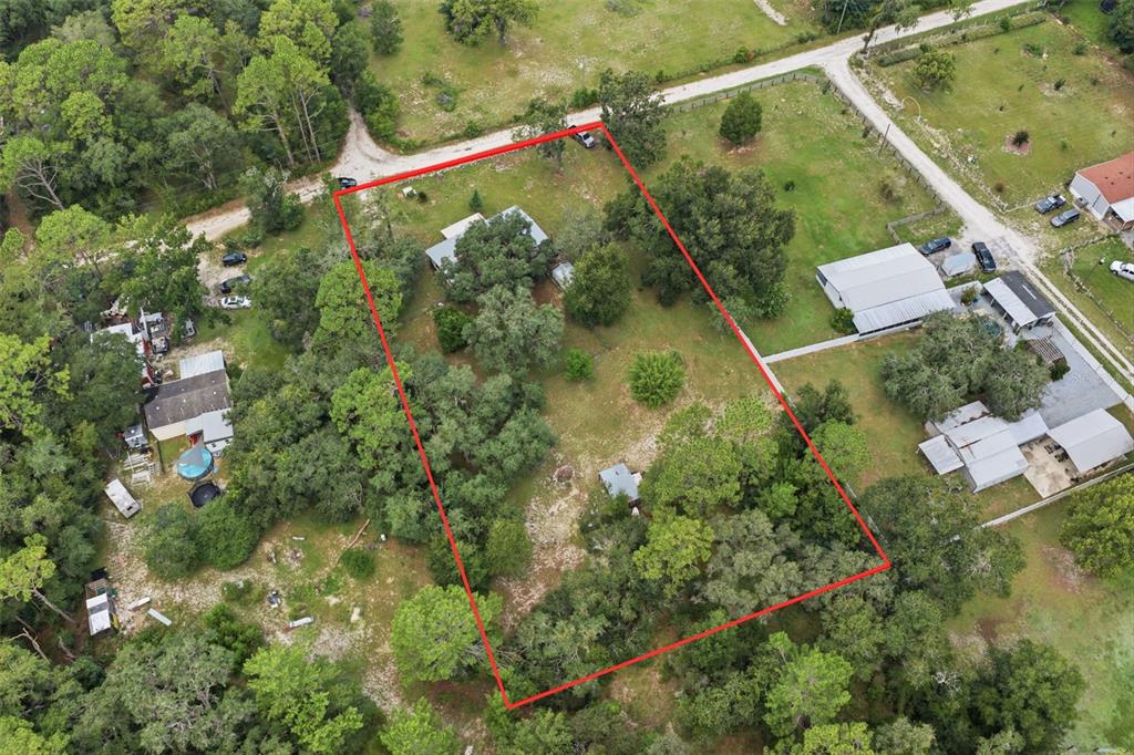 An aerial view shows a rectangular property lot outlined in red containing a house and trees — 6106 DESALES STREET, BROOKSVILLE, FL