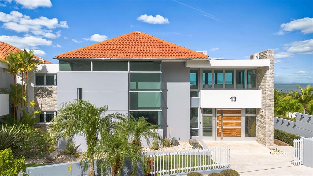 A modern two-story house with a tiled roof, gray siding, and stone accents — _ ROBLE VALLEY UNIT 12 / 13, HUMACAO, PR