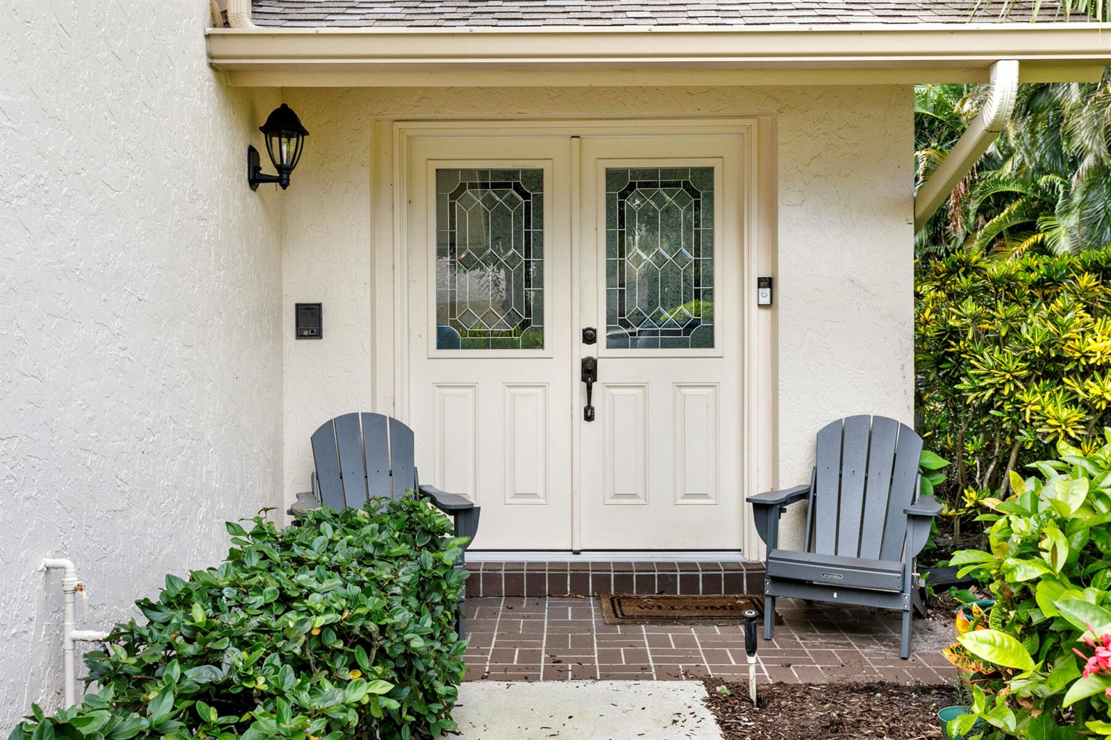 A front entryway features double doors with glass inserts, two gray chairs, and brick flooring — 17137 Waterbend Drive # 201, Jupiter FL 33477, JUPITER, FL