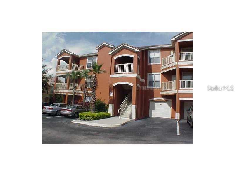 A three-story apartment building with stucco walls, balconies, and a ground-level garage — 8813 VILLA VIEW CIRCLE UNIT 308, ORLANDO, FL