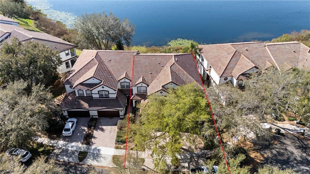 An aerial view shows a multi-story residential building with a tiled roof near a lake — 8224 TIVOLI DRIVE, ORLANDO, FL