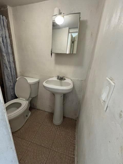 A small bathroom features a pedestal sink, a toilet, and a wall-mounted medicine cabinet — 2451 NW 95th Terrace, Miami FL 33147, MIAMI, FL